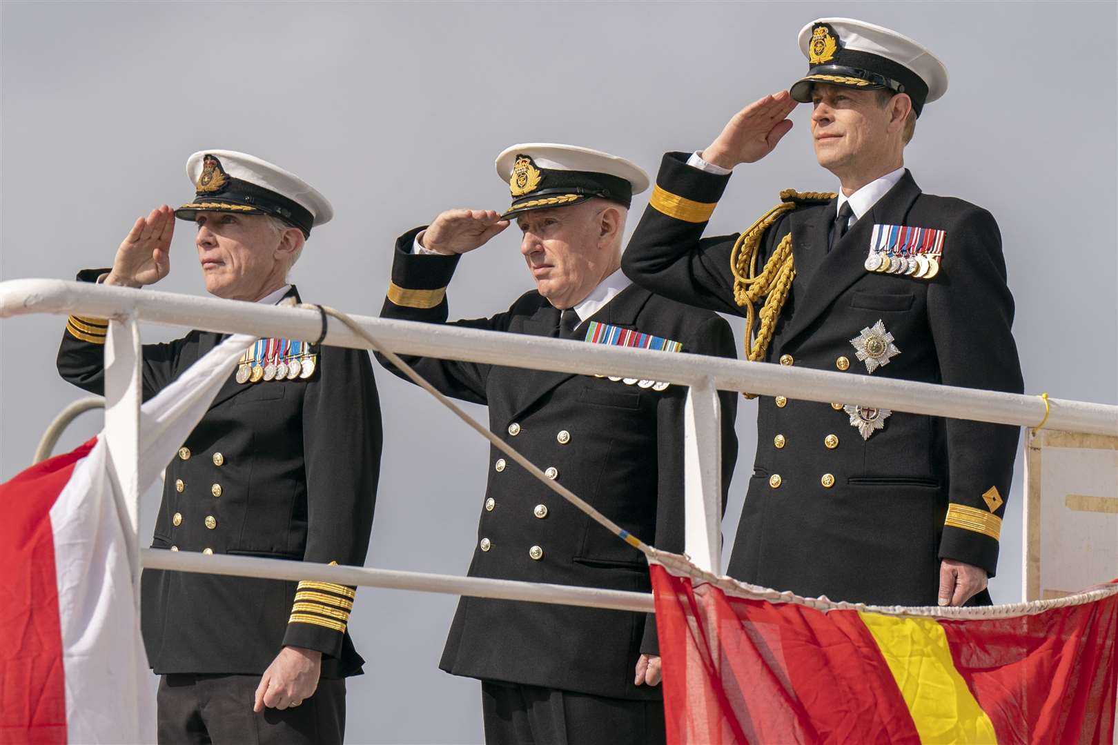 Prince Edward, the Duke of Edinburgh, alongside Commanding Officer Captain Duncan Vernoum (left) and Commodore David Eagles (centre) salute the ship’s ensign during the Service of Dedication (Jane Barlow/PA)