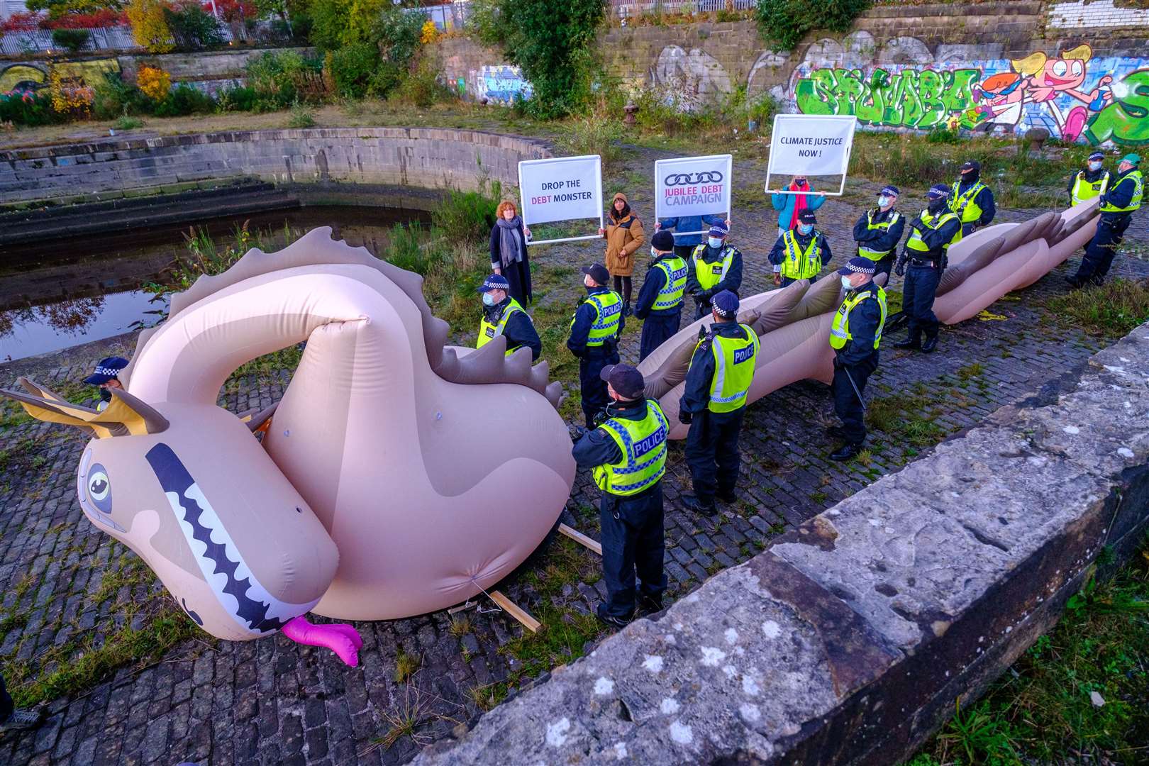 On the banks of the River Clyde near the Cop26 venue, poverty was the subject of a stunt featuring an inflatable Loch Ness Monster (Jess Hurd/PA)