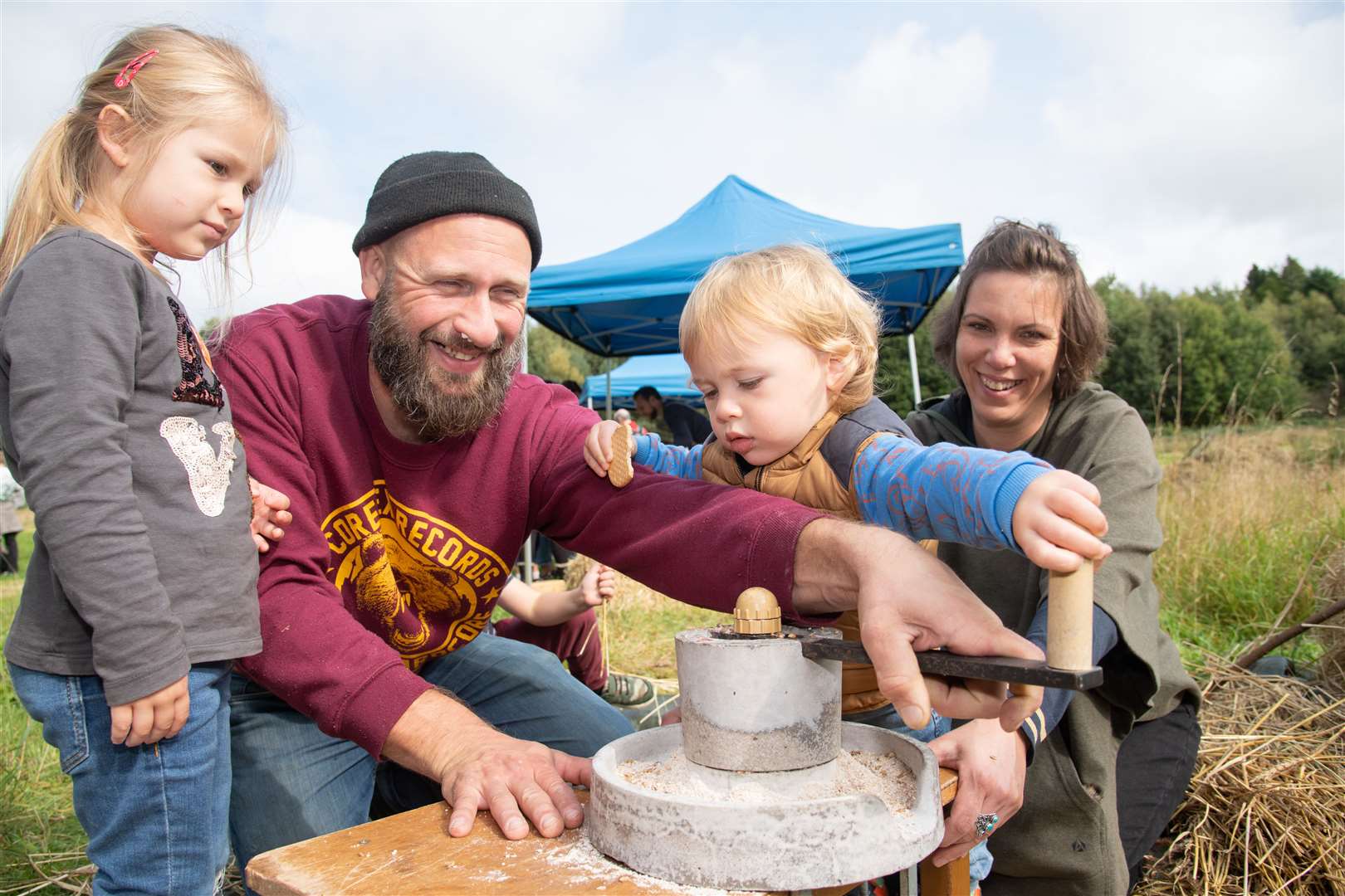 A family try out grinding the grain...Forres Friends of Woods and Fields open harvest day at Chapleton Field. .. Picture: Daniel Forsyth..