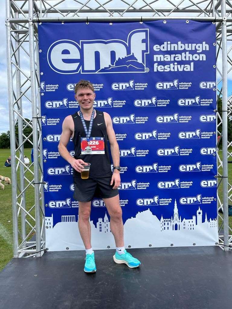 Ross Paterson, beer in hand, at the finishing line of the Edinburgh Marathon.