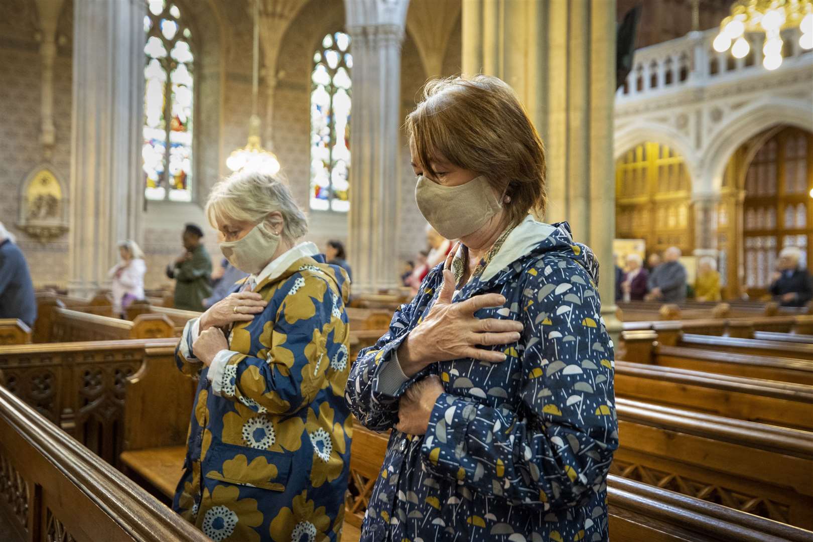 Parishioners wearing face masks bless themselves at the end of mass (Liam McBurney/PA)