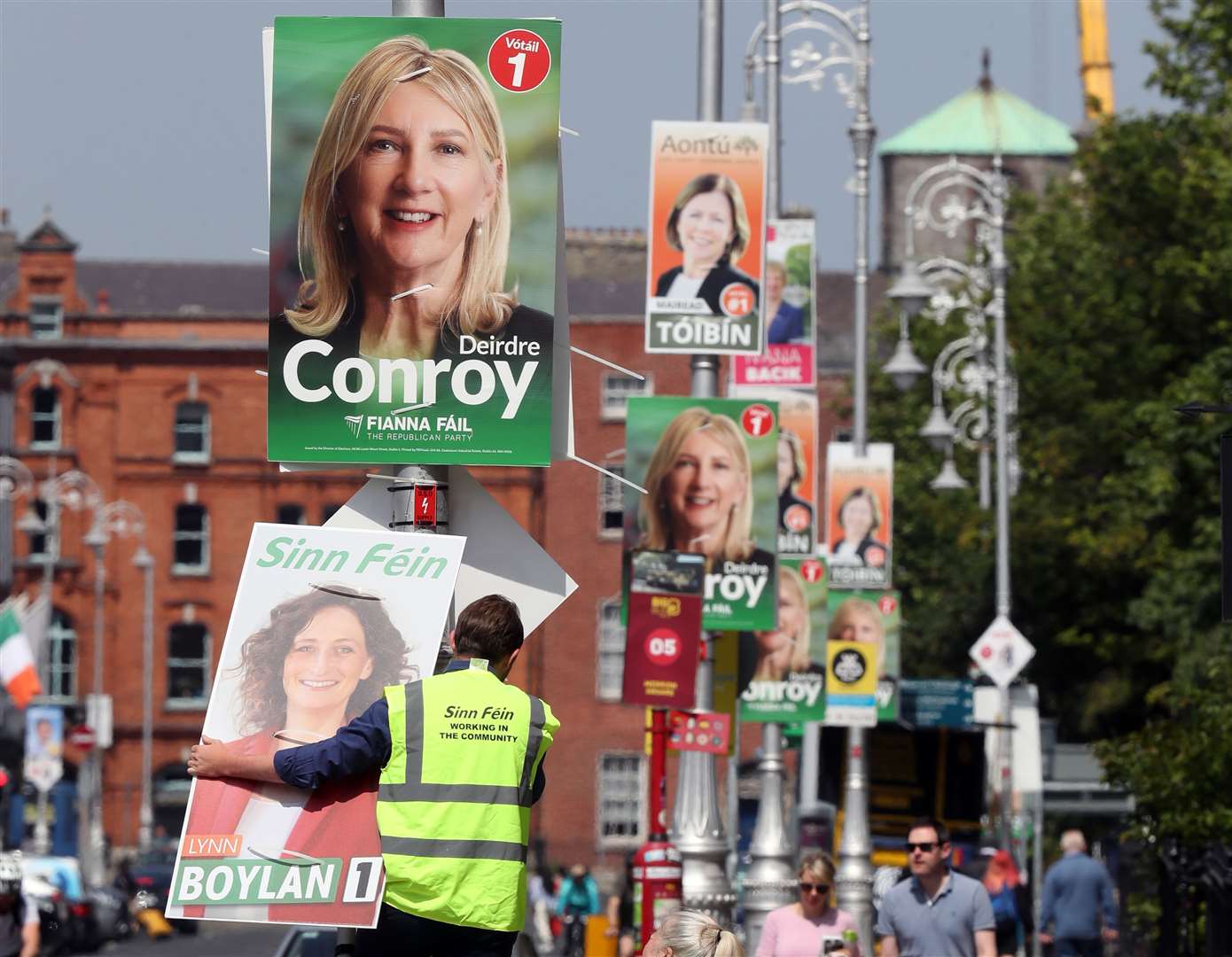 A Sinn Fein election worker puts up a poster of Dublin Bay South by-election candidate Lynn Boylan outside Leinster House (Niall Carson/PA)