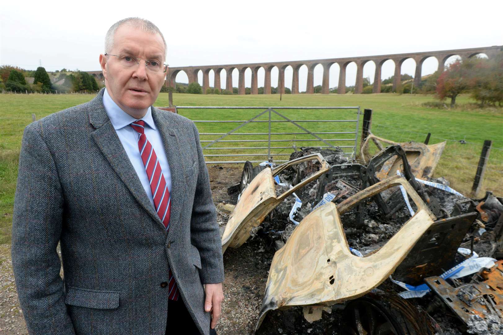 Burnt out car near Nairn Viaduct: Cllr Duncan Macpherson in front of the burnt out vehicle.Picture: James Mackenzie.