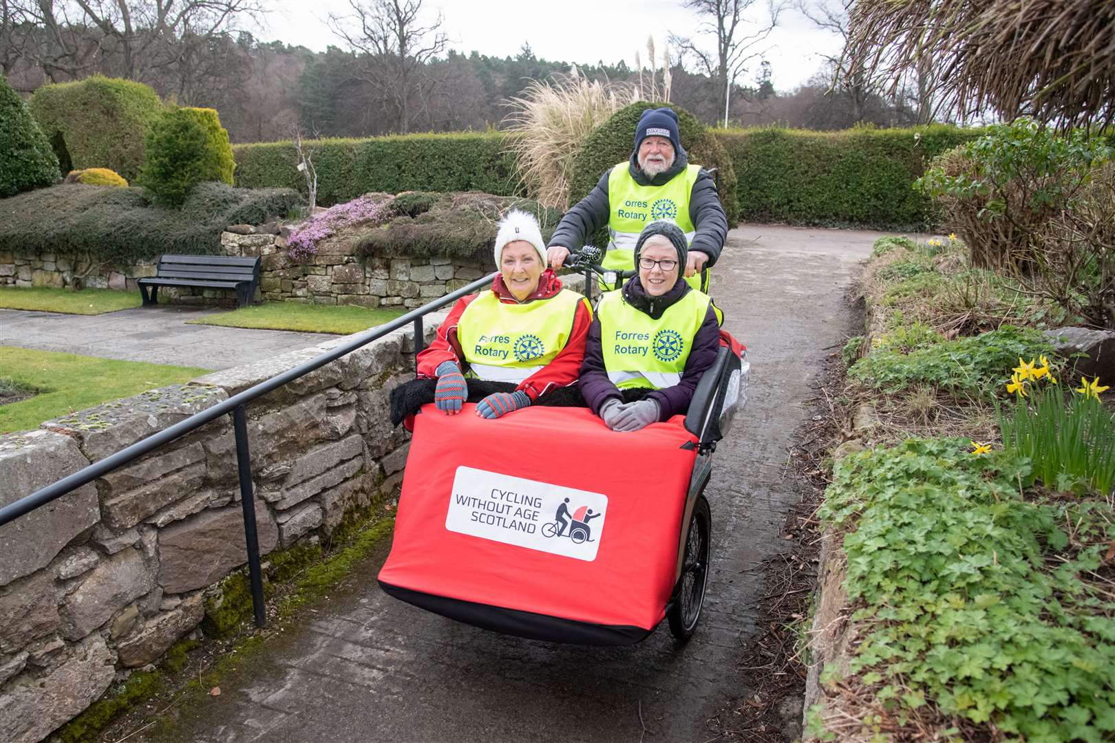 EL_Forres Rotary Trishaw 02The Forres Rotary Club's Jim McPherson (cycling) and Sheena MacGillivray (left) and Suzie De-Vry (right) take a ride on the Cycling Without Age Scotland Trishaw around the sunken garden in Forres. Picture: Daniel Forsyth.