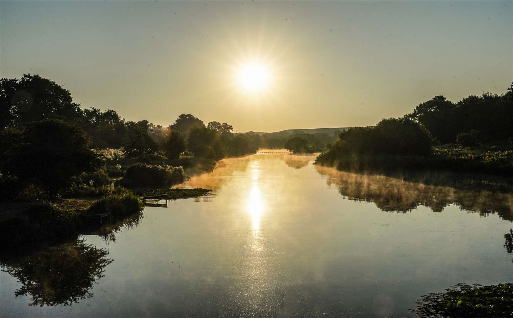 The sun rises over Berwick Pond in Rainham, Essex (Ian West/PA)