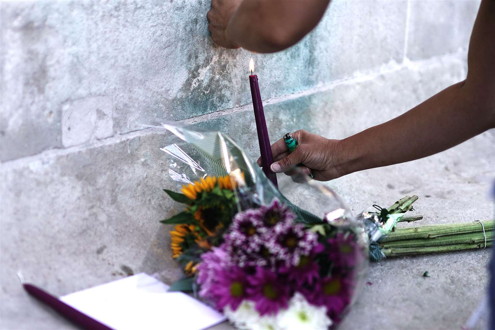 A person lights a candle outside the hospital (Aaron Chown/PA)