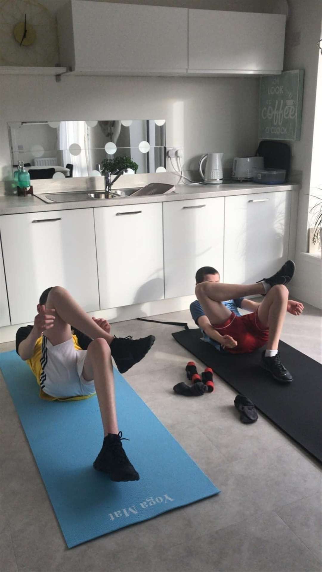 Lucca McCullie and his brother Josh stretching in their kitchen.