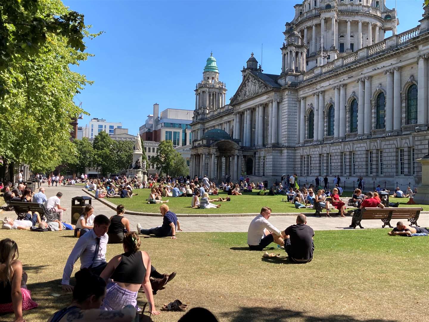 People enjoy an al fresco lunch in the grounds of Belfast City Hall (Rebecca Black/PA)