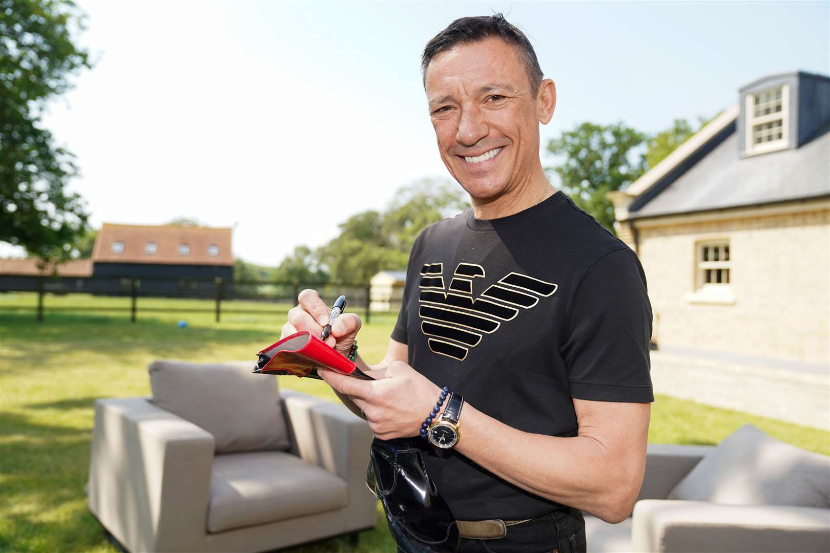 Frankie Dettori signs memorabilia at his home in Newmarket, Suffolk, ahead of the auction (Jacob King/PA)