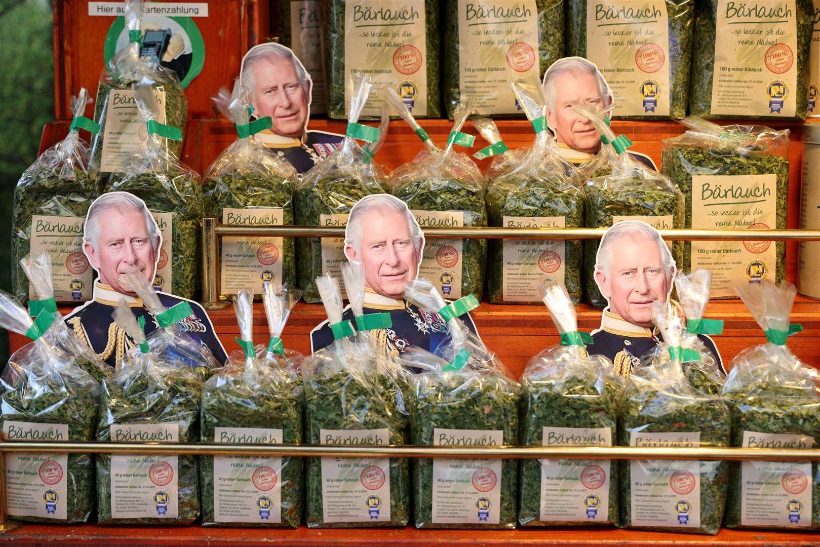 Cardboard cut-outs of the King are seen among packages of wild garlic ahead of his visit with the Queen Consort to the Wittenbergplatz market (Adrian Dennis/PA)