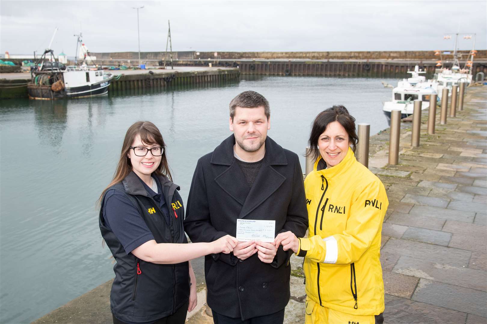 Buckie RNLI’s Rebecca Thomson (left) and Lorna Cameron receive a cheque from Jamie Campbell. Picture: Daniel Forsyth.