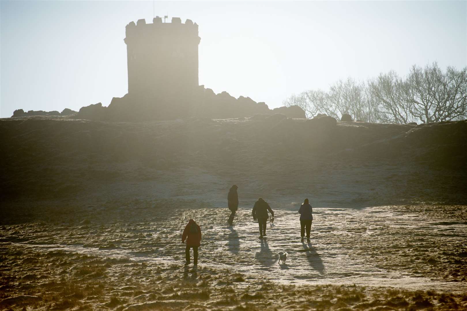 Walkers approach Old John Tower at Bradgate Park in Leicester, on a cold and bright morning across the Midlands (Jacob King/PA)