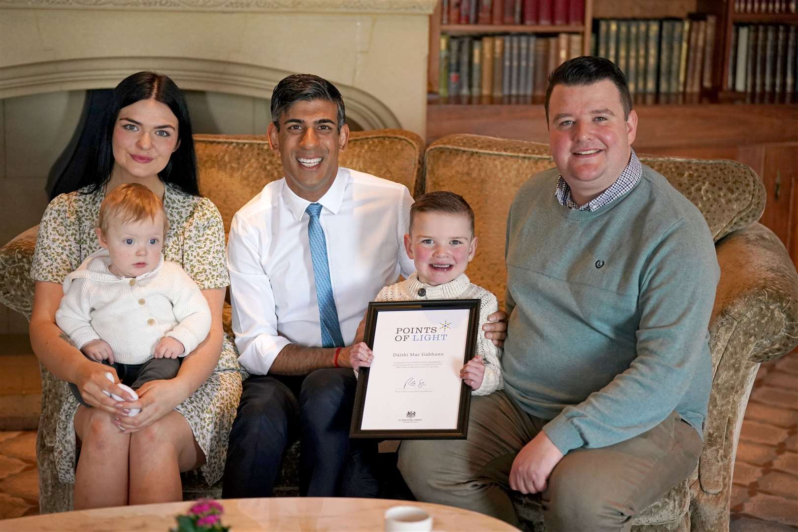 Daithi Mac Gabhann with his father Mairtin Mac Gabhann, mother Seph Ni Mheallain and younger brother Cairbre as he is presented with an award by Rishi Sunak (Niall Carson/PA)