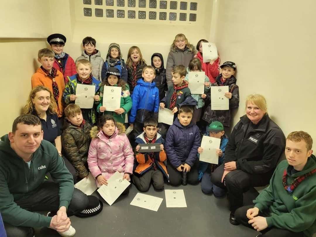 PC Squair (right) and 1st Forres Cubs at the Victoria Road police station.