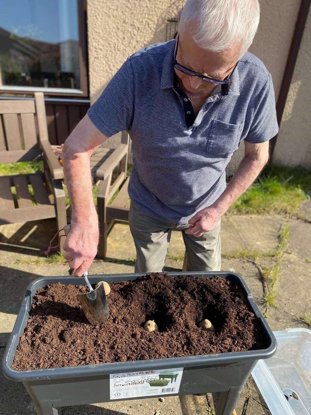 George Stewart planting potatoes.