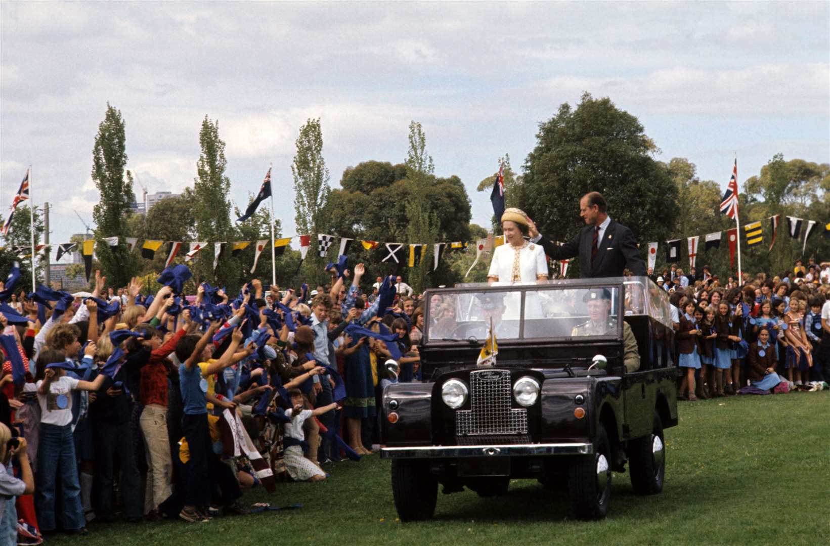 The Queen and Philip in an open Land Rover at a children’s rally in Royal Park, Melbourne (Ron Bell/PA)