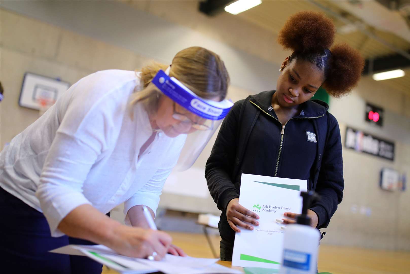 Tenisha Dawkins-Campbell has her results checked over by a teacher (Aaron Chown/PA)