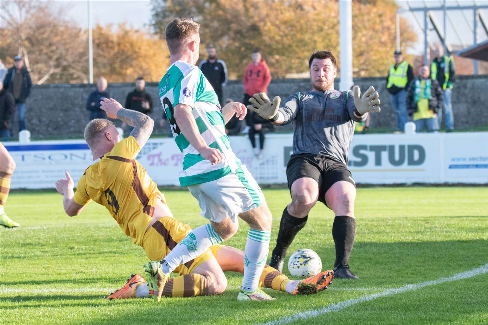 Forres Mechanics' keeper saves well from Buckie forward Josh Peters - as Forres centre back Lee Fraser slides in for a challenge too...Buckie Thistle FC (2) vs Forres Mechanics FC (0) - Highland Football League 22/23 - Victoria Park, Buckie 29/10/2022...Picture: Daniel Forsyth..