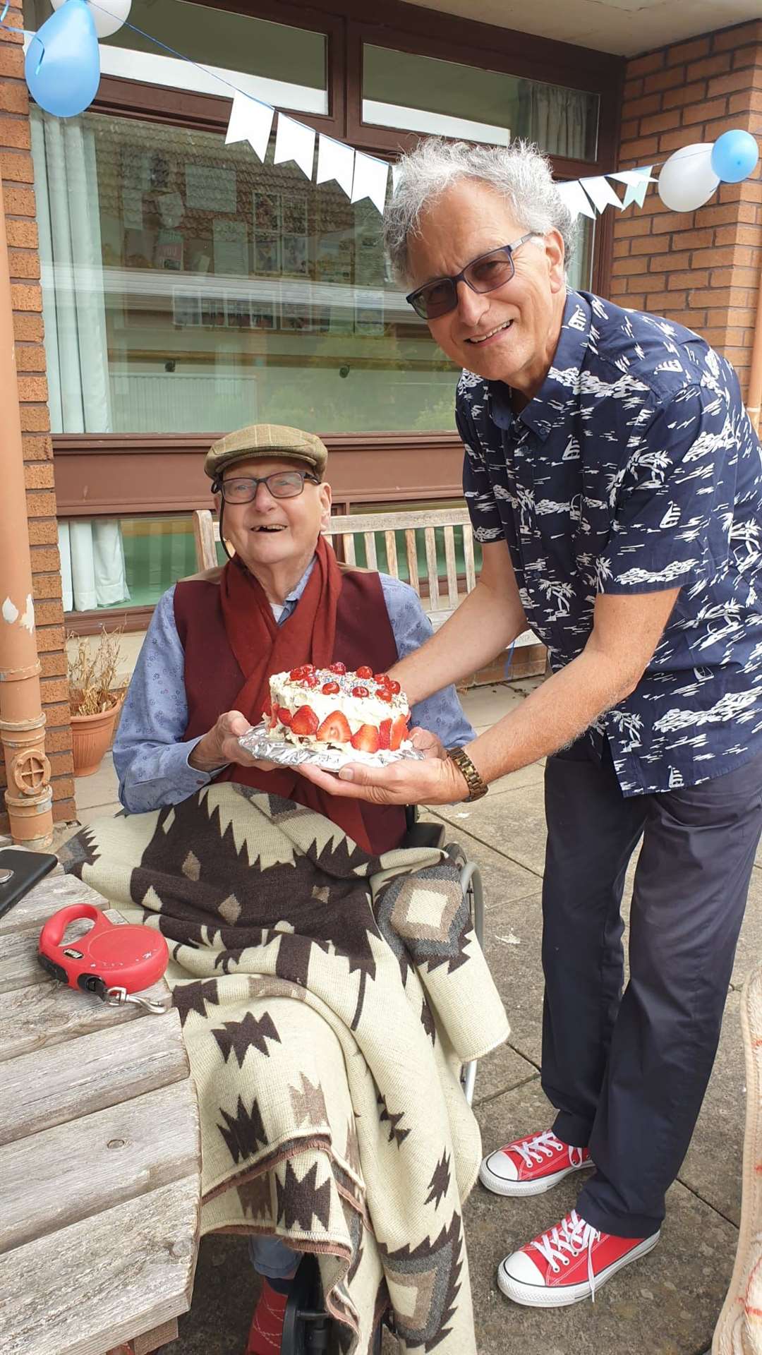 Harry Gamper enjoys cake on his 102nd birthday with his son (Malin Court Care Home/PA)