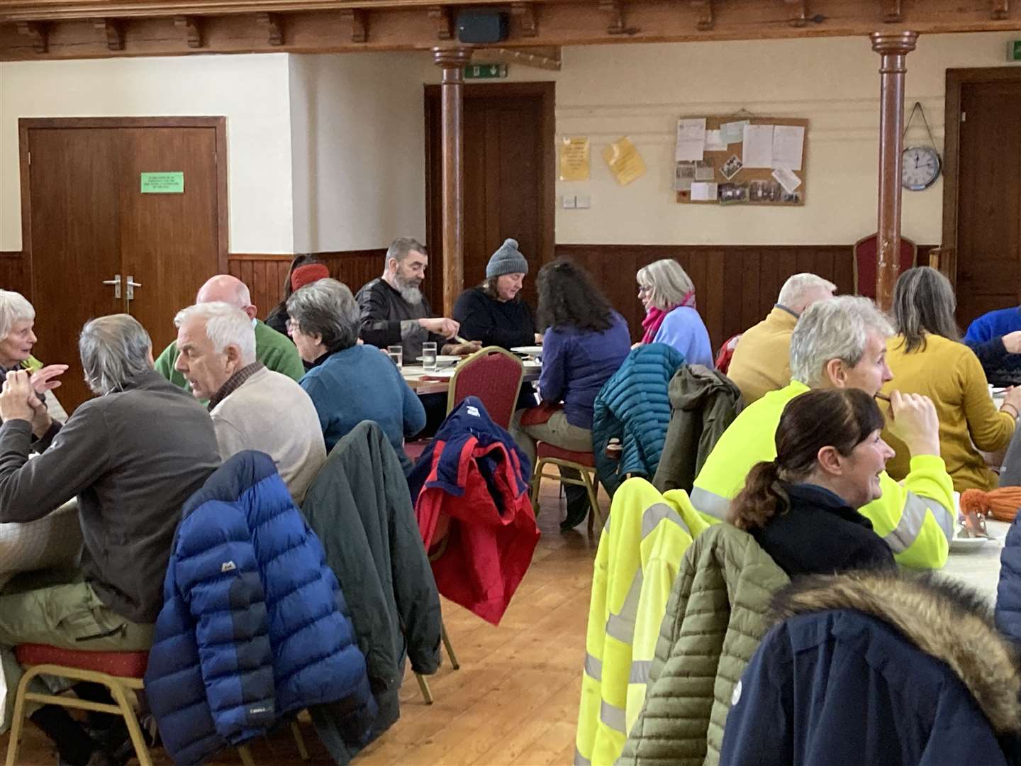 Members of the community chatting over soup in the village hall.
