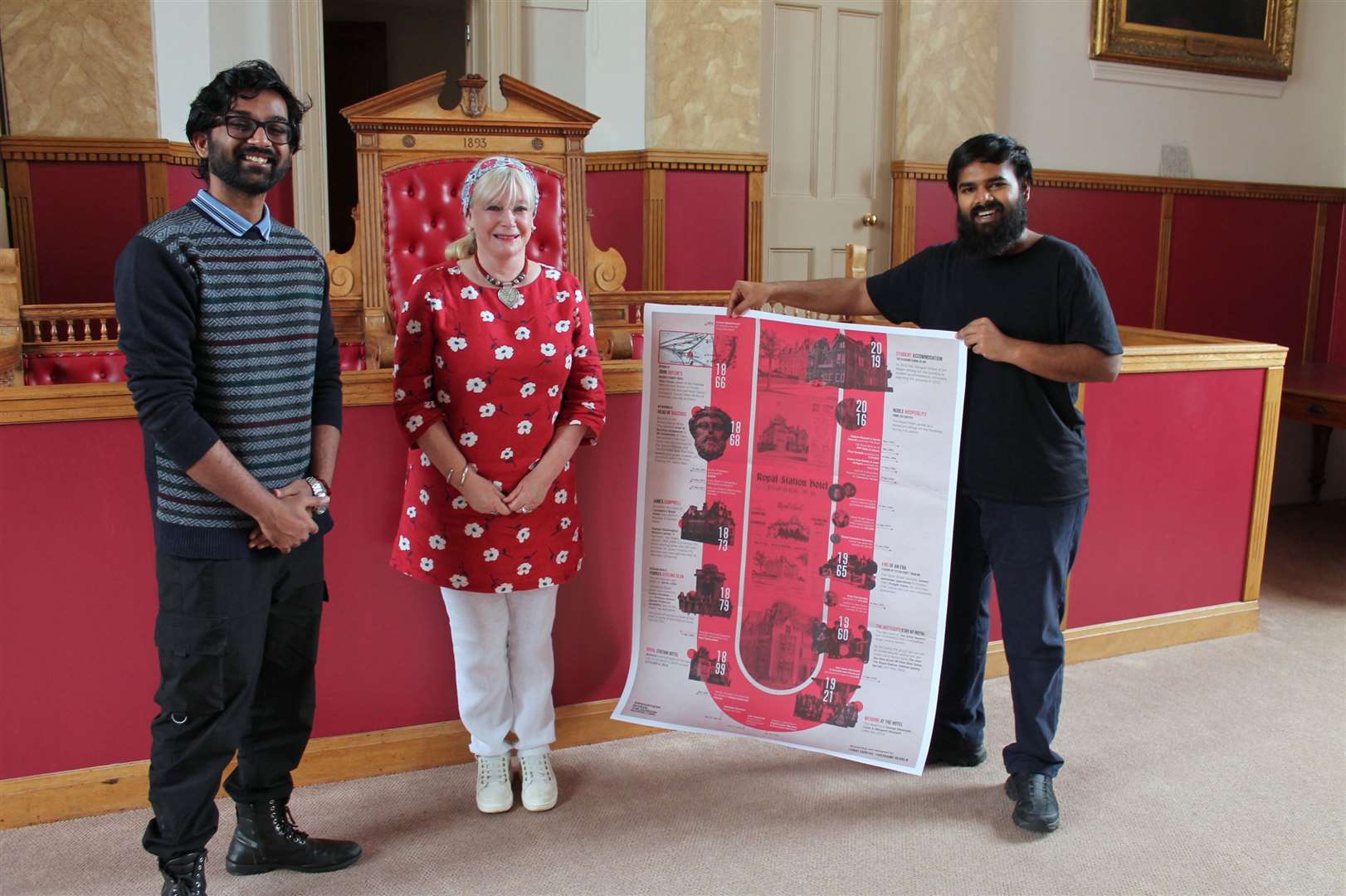 Suraj, Carole, and Shashank at the Courtroom in the Tolbooth with a copy of the Royal Hotel history.