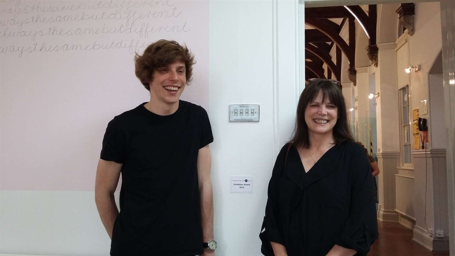 Kim and Sam Welch together at Kim's degree show, standing at her GHAT Exhibition Award.