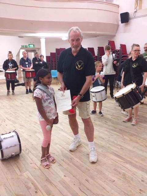 Erina Hamilton receiving her Level 7 Tenor Drum certificate from band chairman John at Forres Town Hall.