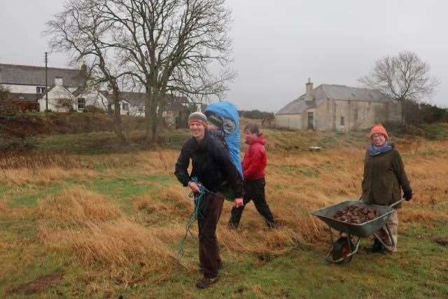 Val, Rory and Doug pulling a heavy barrow of stones.